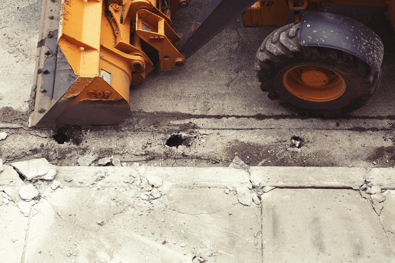 ASF Constructs civil works — yellow earth-moving equipment and TLB on a Cape Town site